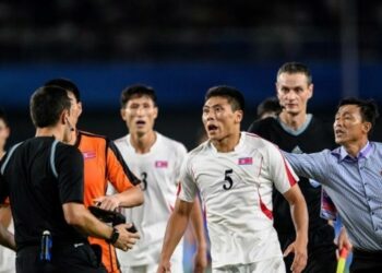 Pemain timnas Korea Utara, Kim Kyong Sok (tengah), berusaha menyerang wasit usai laga perempat final sepak bola putra Asian Games 2022 melawan Jepang yang digelar di Xiaoshan Sports Centre, Hangzhou, pada Senin (1/10/2023) malam WIB.(AFP/PHILIP FONG)